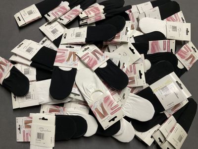 de nombreuses paires de chaussettes noires et blanches posées sur une table