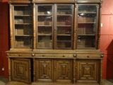 a wooden china cabinet with glass doors in a room