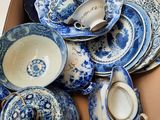 une boîte remplie d'assiettes et de tasses bleues et blanches