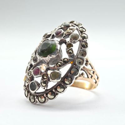 une image représentant une bague en argent ornée d'une pierre verte au centre