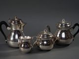 three silver teapots and a silver coffee pot on a table