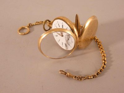une montre de poche en or à laquelle est attachée une chaîne