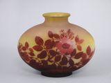 un vase jaune orné d'une fleur rose
