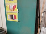a green refrigerator in a room with a ladder next to it