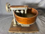 une vieille machine en bois et en métal, surmontée d'un bol en bois
