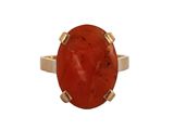 un gros plan d'une bague en pierre rouge sur fond blanc