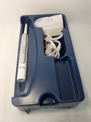 un plateau bleu contenant une brosse à dents, un chargeur et d'autres objets