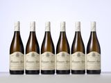 six bottles of wine are lined up on a table