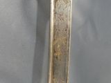 a gold and silver sword on display on a blue cloth