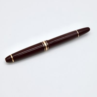 a close up of a pen on a white surface with a white background