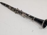 a black and silver clarinet sitting on a white surface