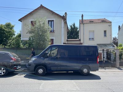 des voitures garées sur un parking devant une maison