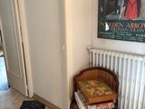 a chair and a table in a room with a painting on the wall