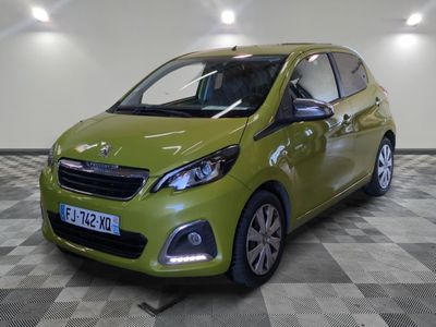 La petite voiture verte est garée sur un sol à damier.