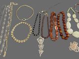 Plusieurs colliers et bracelets différents sont disposés sur un support gris.