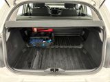 the back of a white car with the trunk open and a tool box in the trunk