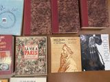 several books on a table with a clock on top of them