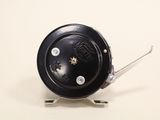 a close up of a black clock on a white surface