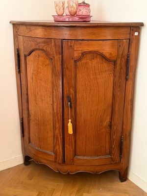 une armoire en bois sur laquelle est posé un vase rose