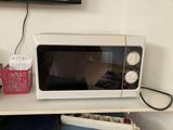 un micro-ondes posé sur une étagère dans une pièce