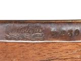 a close up of a knife on a piece of wood