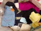 a pile of clothes in a basket on a bed
