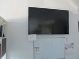 un téléviseur accroché au mur dans un coin de la pièce