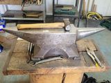 a metal anvil sitting on a table in a garage