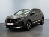 un SUV gris garé dans une pièce aux murs blancs