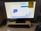 a computer monitor sitting on top of a wooden desk