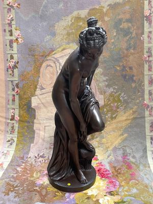 a statue of a woman kneeling down on a table