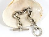 silver chain and keychain on a clam shell on a white background