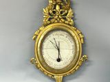 a gold clock on the wall with a bird on it