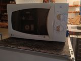 a microwave sitting on top of a box in a warehouse