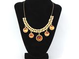 un collier en or orné de pierres orange sur un mannequin noir