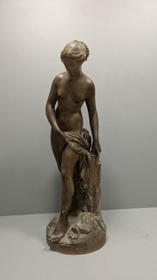 statue d'une femme assise sur une souche d'arbre dans une pièce