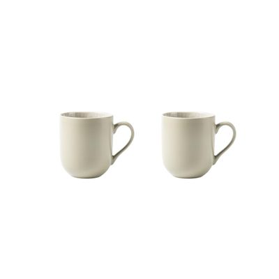 two white coffee cups sitting next to each other on a white surface