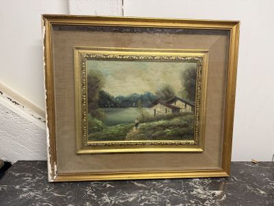 un tableau représentant une scène de vie à la ferme, dans un cadre doré, posé sur une table