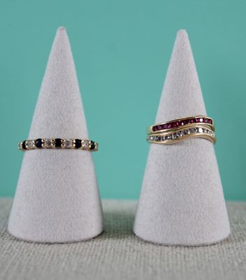 deux bagues en or ornées de diamants noirs et blancs sont posées au sommet d'un cône