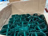 une boîte remplie de pièces en plastique vert, elle-même placée dans une boîte