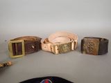 three belts and a hat are sitting on a table