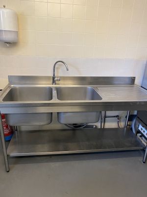 a stainless steel sink in a kitchen with a microwave