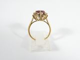 a close up of a gold ring with a ruby stone