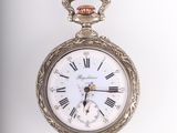 une montre de poche en argent avec des chiffres romains sur le cadran
