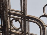 a close up of a metal gate with a clock on it