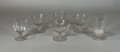 six verres à vin transparents posés sur une table blanche