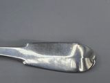 an old silver spoon on a gray surface with a small spoon sticking out of it