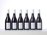 six bottles of red wine lined up in a row