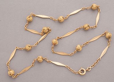 a close up of a gold chain with beads on it