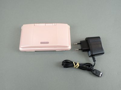 une boîte rose à laquelle est fixé un chargeur